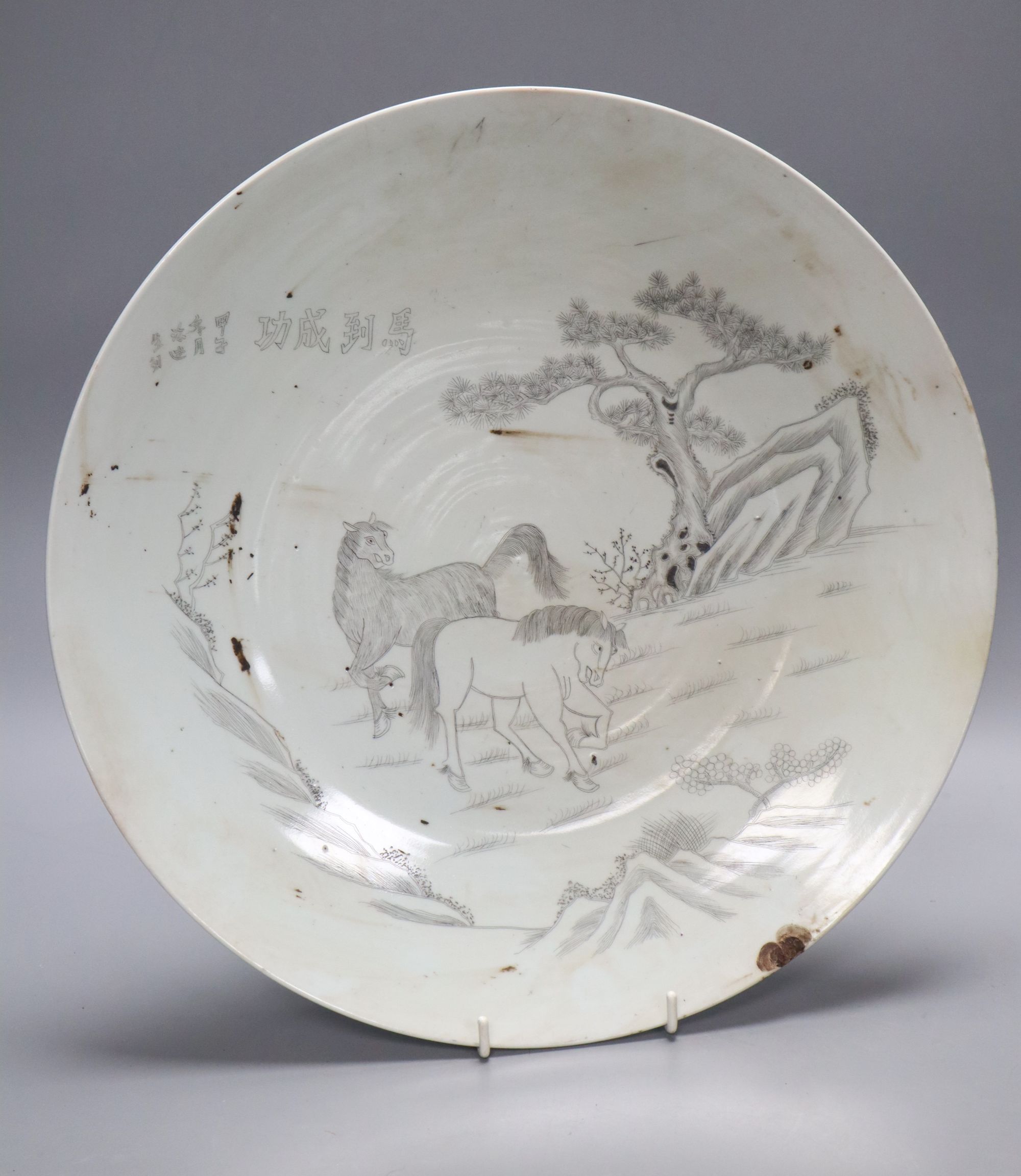 A Chinese porcelain dish engraved with horses, rocks and pine, diameter 33.5cm